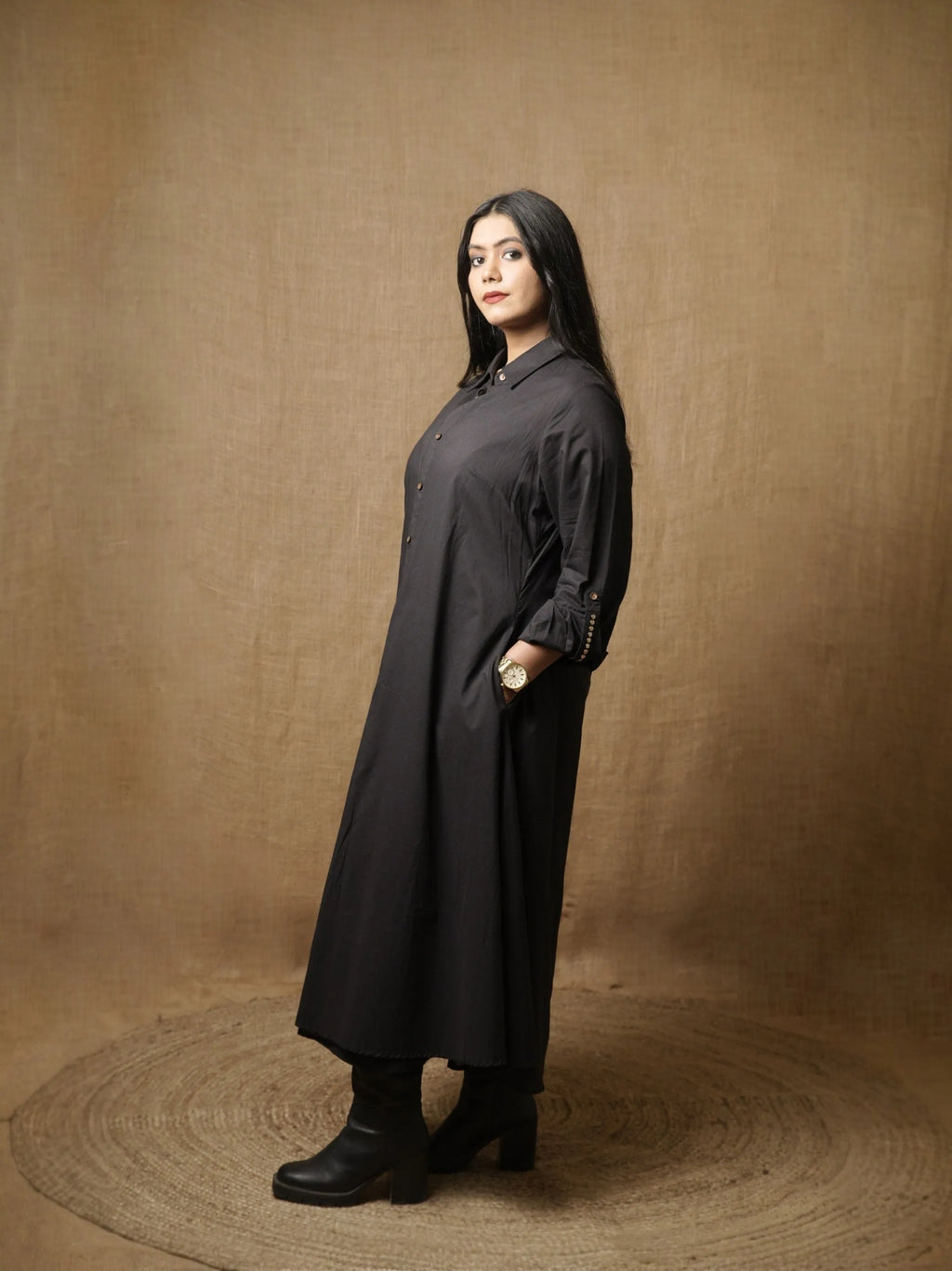 Black A-line shirt dress with button front and long sleeves, side view